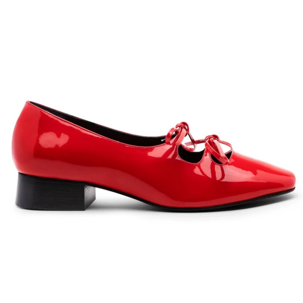 Nicole Saldana Isabel in cherry red patent leather pumps with lace up detail.
